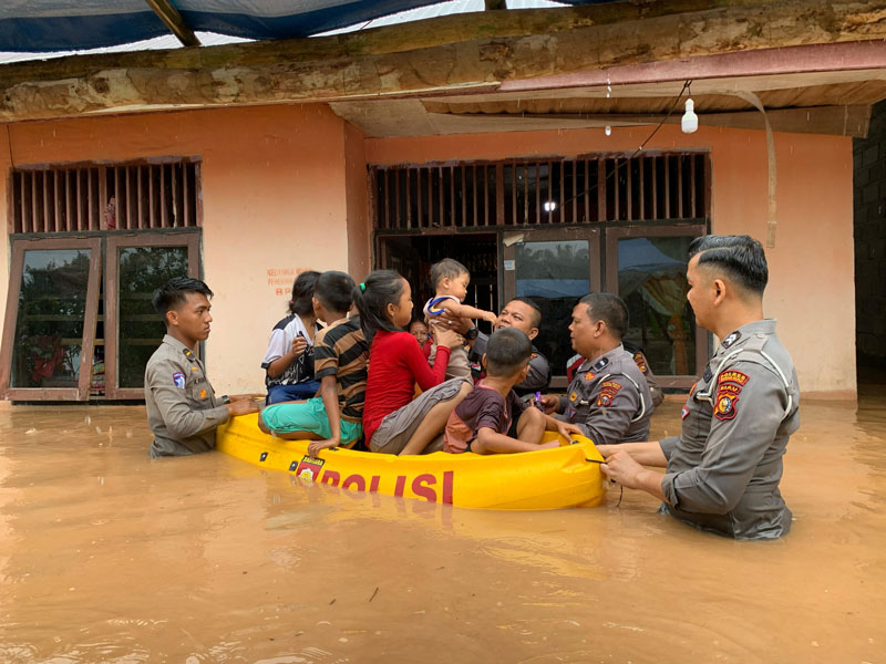 Personel BPBD, Polri, dan TNI melakukan evakuasi terhadap anak-anak yang rumahnya terendam banjir di Rokan Hulu, Kamis (27/2/2025).