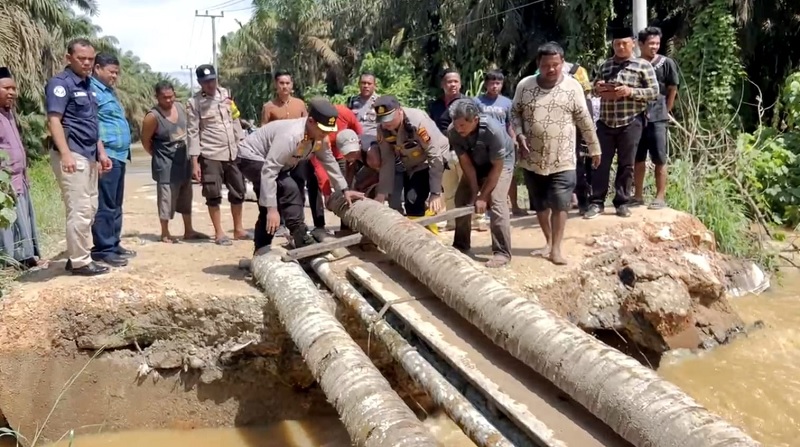 Kapolres Rohul AKBP Budi Setiyono goro bersama masyarakat membangun jembatan darurat, paska Jembatan Horas di Kelurahan Kota Lama Tergerus Luapan Air Sungai Rokan,  Jumat (28/2/2025).