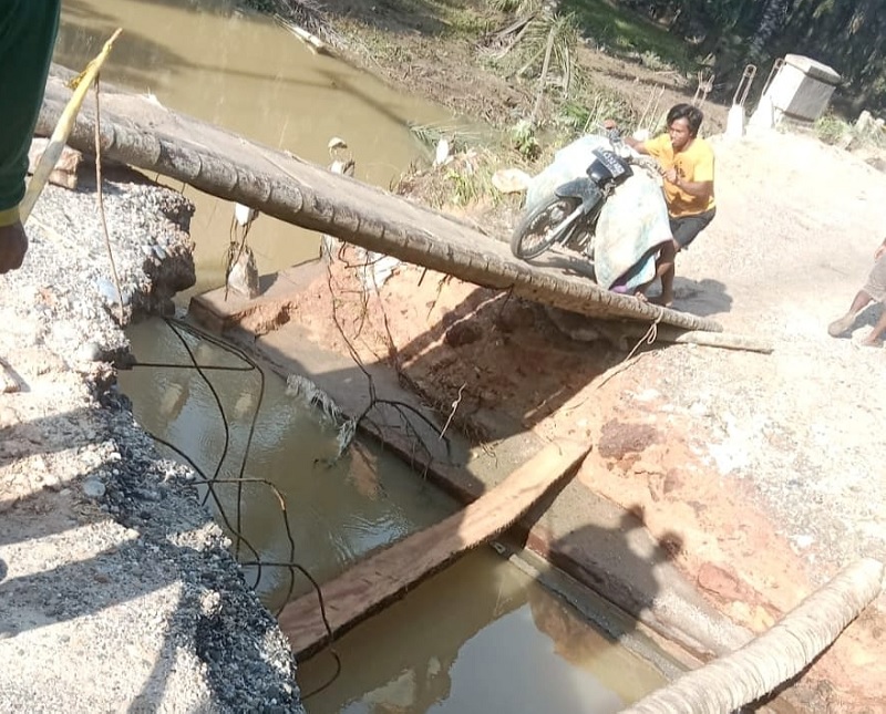 Seorang warga mendorong kendaraan roda dua di jembatan darurat pascatergerusnya Jembatan Horas di Kelurahan Kota Lama, Ahad (2/3/2025).
