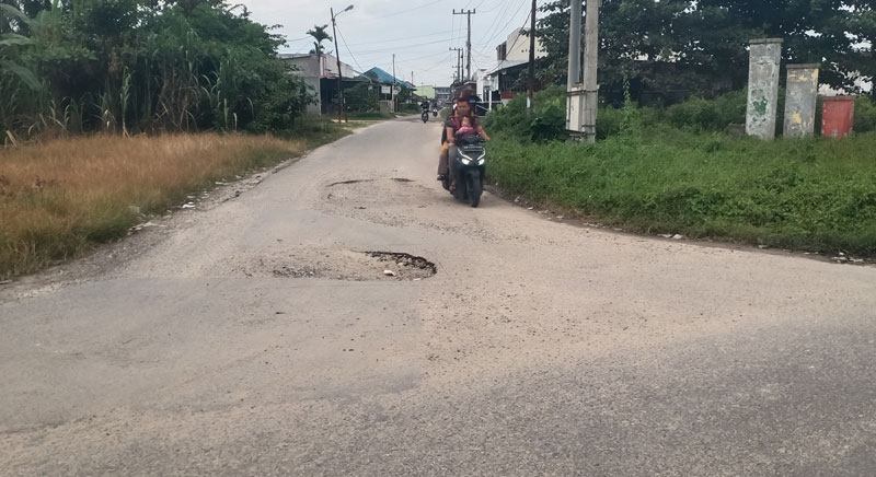 Pengendara sepeda motor melintasi Jalan Seminai Pangkalankerinci yang mengalami kerusakan, Senin (3/3/2025).