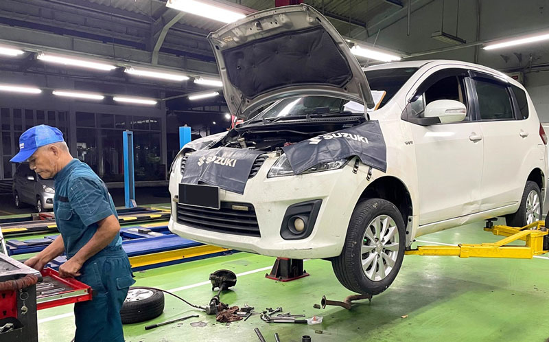 Seorang mekanik melakukan servis mobil Suzuki di bengkel resmi, beberapa waktu lalu.