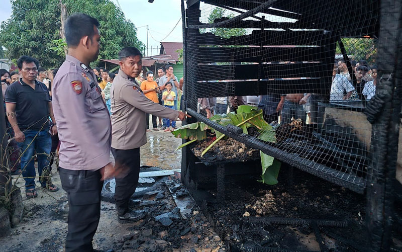 Petugas kepolisian saat melakukan olah TKP atas meninggalnya seorang remaja dalam peristiwa kebakaran rumah di Jalan Lintas Duri-Pekanbaru.