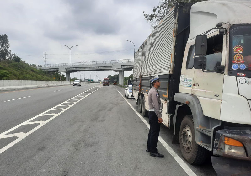Petugas dari Ditlantas Polda Riau saat menilang satu unit truk over dimensi  over loading di Jalan Tol Pekanbaru-Dumai, baru-baru ini.