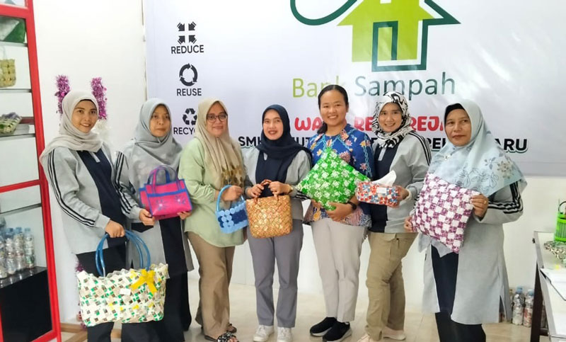 Para pengurus Bank Sampah Wana Reja Reja SMKKN Pekanbaru foto bersama dengan hasil kerajinan, Selasa (4/3/2025).