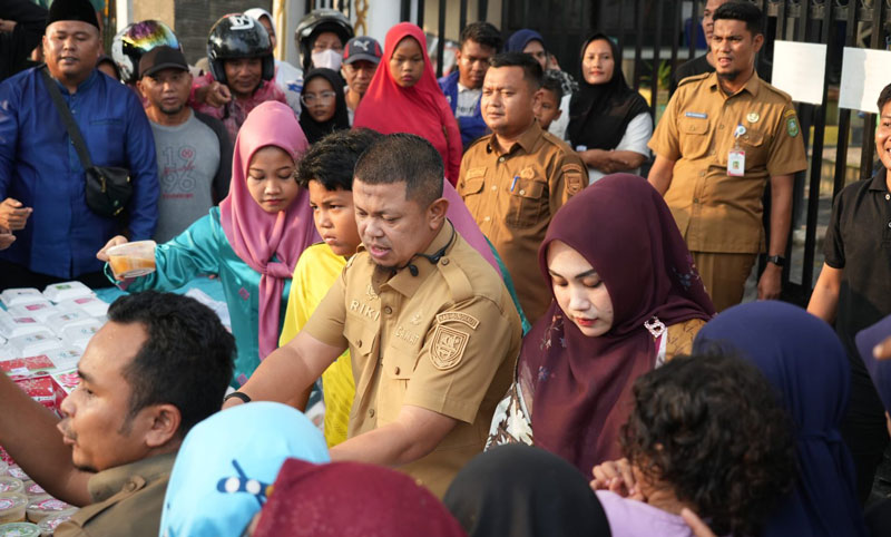 Camat Mandau Riki Rihardi membagi-bagikan takjil untuk berbuka puasa bagi masyarakat di Kota Duri yang digerlar di depan Kantor Camat Mandau, Selasa (4/3/2025) sore.