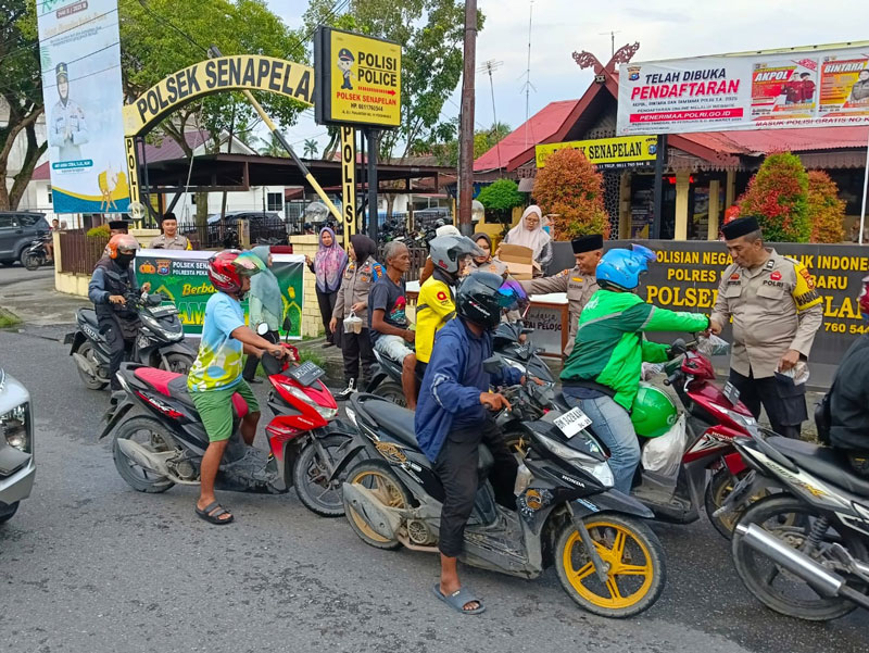Kapolsek Senapelan AKP Akira Ceria bersama jajaran membagikan takjil kepada masyarakat dan pengendara yang melintas di depan kantor Polsek Senapelan.