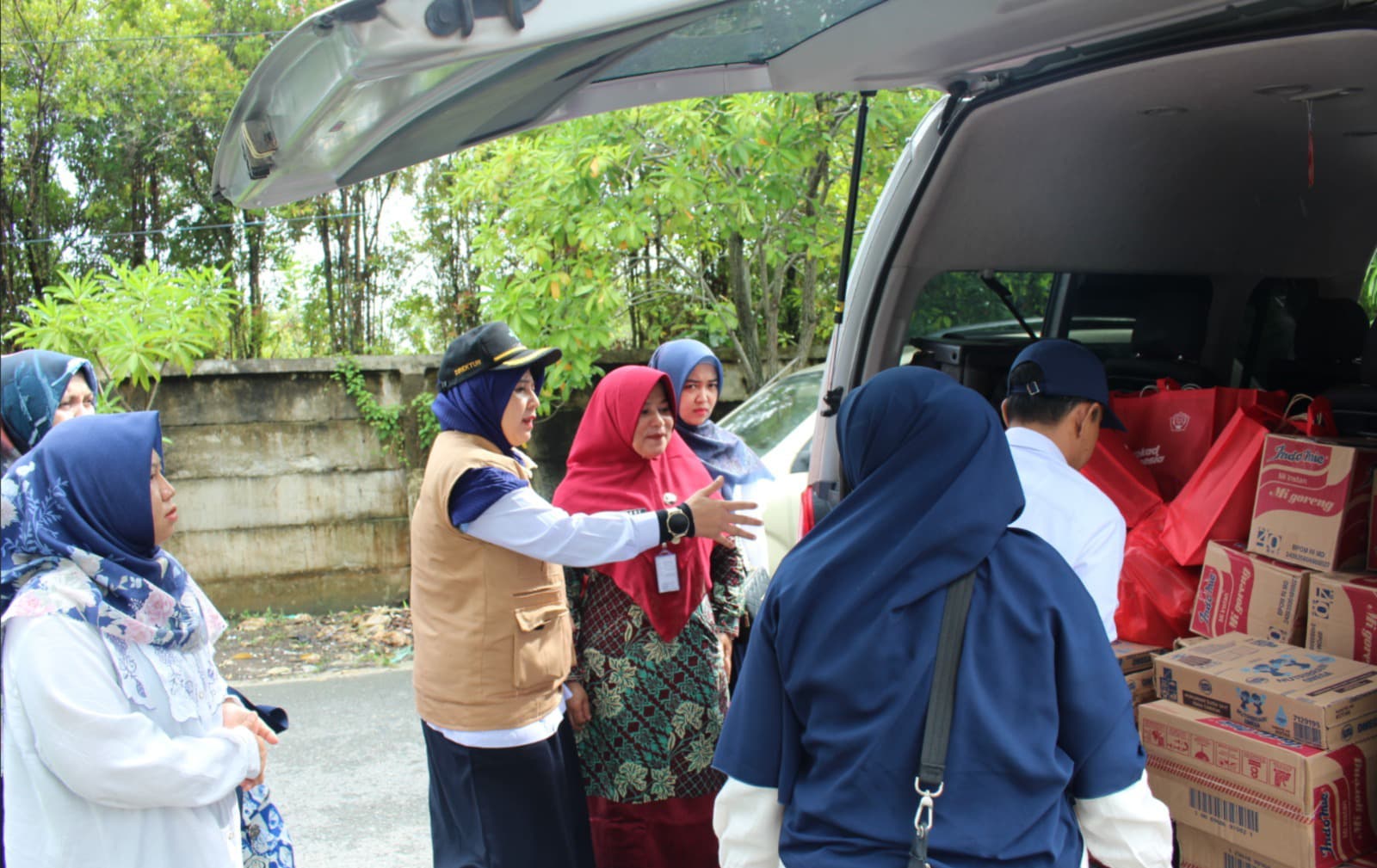 Direktur Poltekkes Kemenkes Riau, Rully Hevrialni, SST, Bdn, MKkeb, MH (tengah) bersama tim saat menyalurkan bantuan kepada warga yang terdampak banjir akibat luapan Sungai Siak, Kamis (6/3/2025).