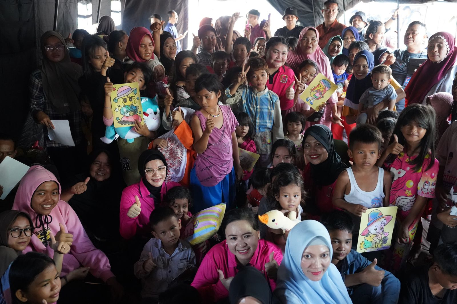Ketua Bhayangkari Daerah Riau Nindya M Iqbal berfoto bersama anak-anak yang berada di tenda pengungsian banjir di Kelurahan Sri Meranti, Rumbai, Jumat (7/3/2025).