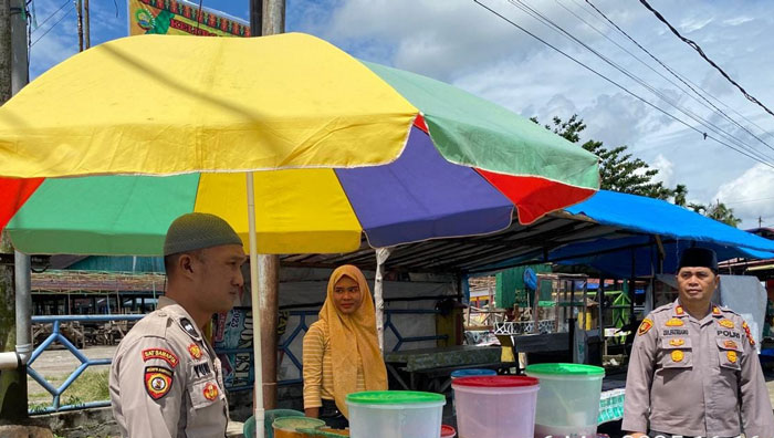 Personel Polsek Pangean melakukan pengamanan pasar Ramadan di Pasar Baru Pangean, Kamis (6/3/2025) sore.