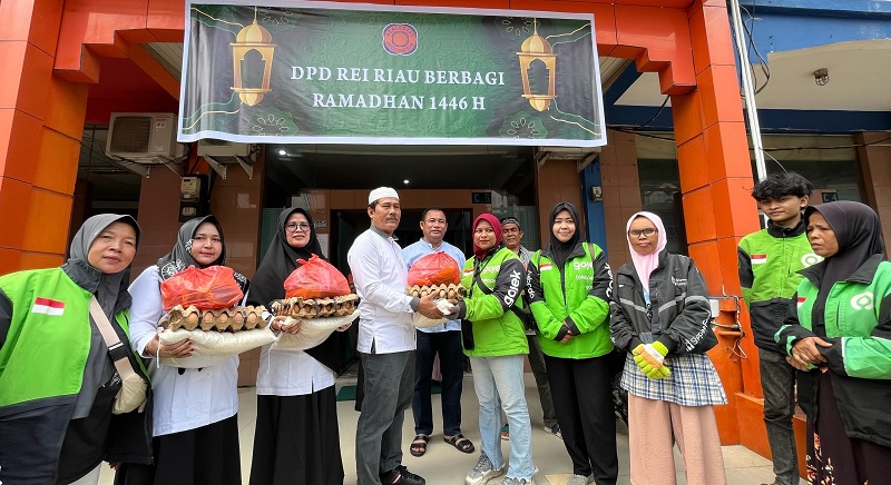 Ketua DPD REI Riau, Elvi Syofriandi (tengah, peci putih) menyerahkan paket sembako kepada driver ojol, petugas kebersihan dan kaum duafa di Kantor DPD REI Riau, Jumat (7/3/2025).