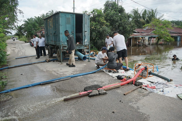 Sejumlah petugas dari Balai Wilayah Sungai Sumatera III Kementerian Pekerjaan Umum memompa air dari kawasan tergenang di Jalan Nelayan Pekanbaru, Senin (10/3/2025).