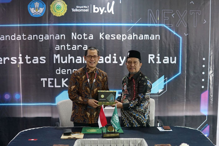 GM Consumer Business Region Sumbagteng, Fahmy Rojali dan Rektor Universitas Muhammadiyah Riau, Dr H Saidul Amin MA memperlihatkan nota kesepahaman bersama usai diteken di kampus Umri, baru-baru ini