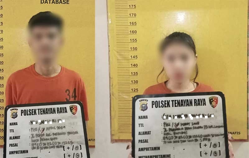 Pasangan suami-istri inisial NS dan GM saat diamankan di Polsek Tenayan Raya,