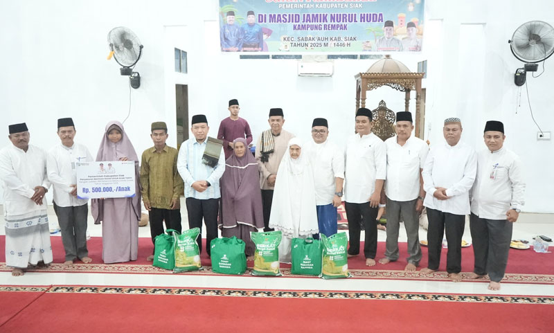 Wabup Siak Husni Merza foto bersama warga penerima manfaat saat Safari Ramadan di Masjid Jamik Nurul Huda Kampung Rempak, Kecamatan Sabak Auh.