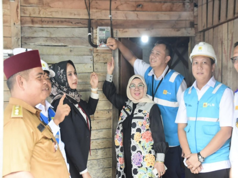 Wakil Bupati Kampar  Misharti secara simbolis melakukan langsung penekanan kontak salah satu meteran listrik atau kWh milik warga di Desa Tarai Bangun, Kecamatan Tambang.