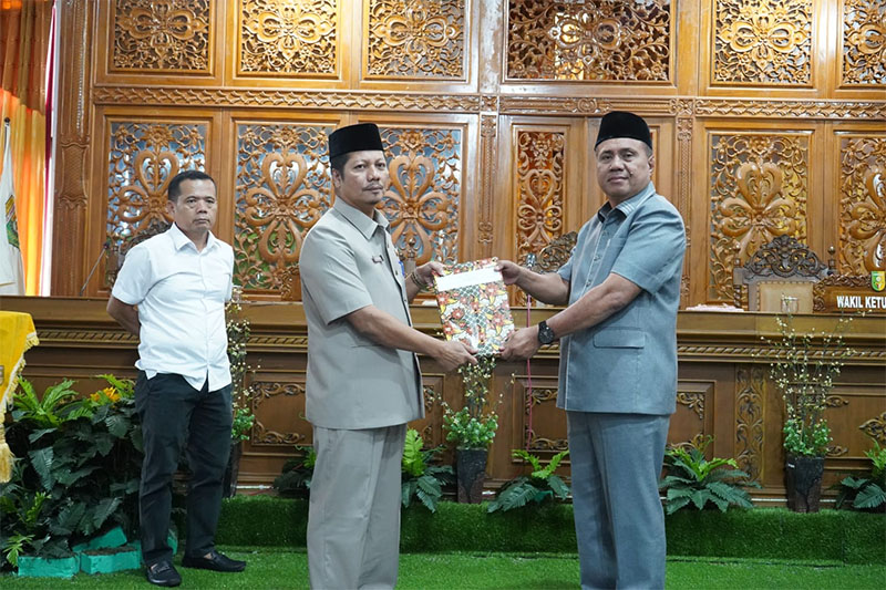 Wabup Kuansing H Muklisin menyerahkan buku tiga Ranperda pada Ketua DPRD Kuansing H Juprizal SE MSi pada paripurna, Rabu (12/3/2025).