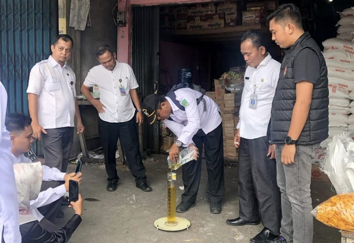 Tim gabungan Polres dan Disperindag Rohul menakar ulang kemasan minyak kita ukuran 1 liter di dalam bejana di satu toko sembako di Kecamatan Rambah, Rabu (12/3/2025).