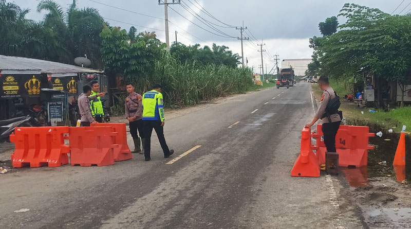 Personel Polres Pelalawan melakukan pengawasan saat diberlakukan lalu lintas sistem buka tutup di Jalan Lintas Timur Km 76-83 Desa Kemang, Kecamatan Pangkalan Kuras.