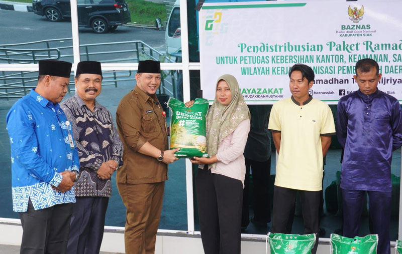 Asisten III Setdakab Siak Rozi Chandra menyerahkan secara simbolis paket sembako Baznas di Kantor Baznas, Kabupaten Siak, Selasa (11/3/2025).