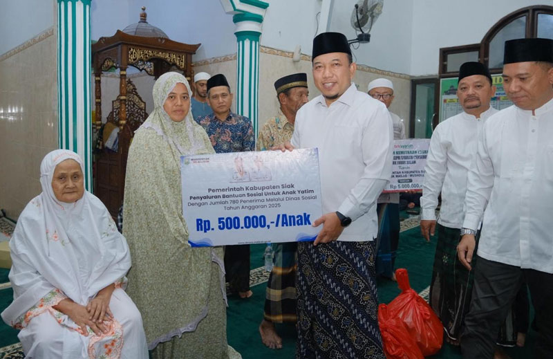 Wabup Siak Husni Merza menyerahkan tanda mata bagi yang berhak menerimanya saat safari Ramadan di Masjid Nurul Huda, Kampung Gabung Makmur.