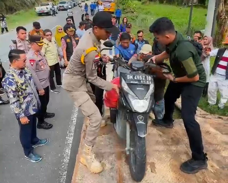 Petugas menaikkan sepeda motor warga ke truk towing gratis yang disediakan Pemkab Pelalawan di Simpang Kualo Dusun Kualo, Kelurahan Pangkalankerinci Kota.