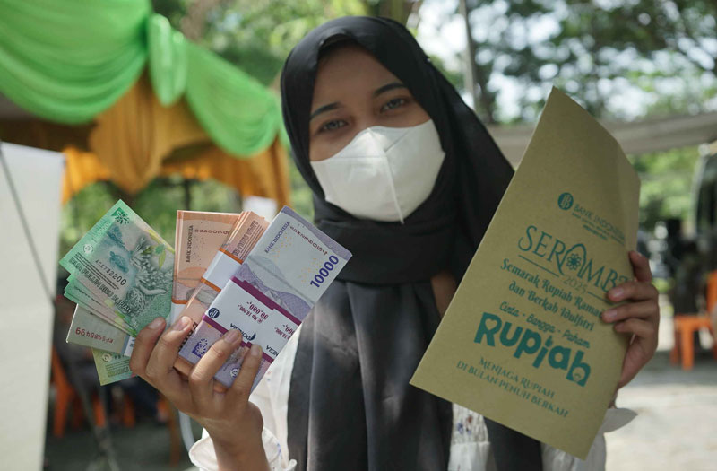 Warga memperlihatkan uang pecahan baru di kegiatan penukaran uang di kawasan Masjid Al Falah, Pekanbaru, Kamis (13/3/2025).