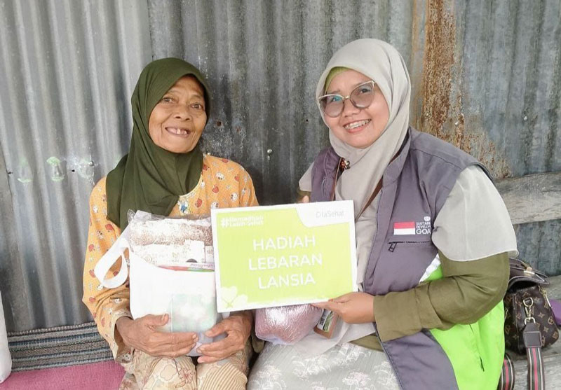Mbah Sepi (kiri) tersenyum ceria menerima paket sehat Klinik Cinta Sehat Pekanbaru dari donatur, Kamis (13/3/2025).
