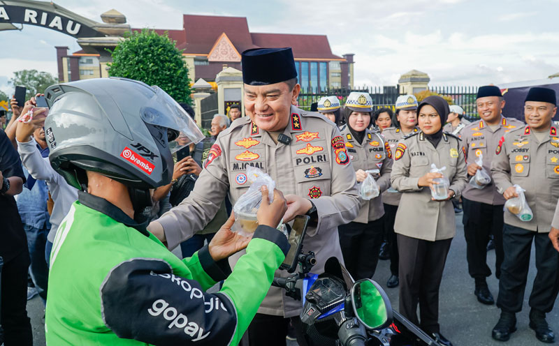 Kapolda Riau Irjen Pol Mohammad Iqbal didampingi Wakapolda Brigjen Pol Adrianto Jossy Kusumo dan PJU Polda Riau berbagi takjil kepada warga yang melintas di Jalan Pattimura, depan Mapolda Riau.