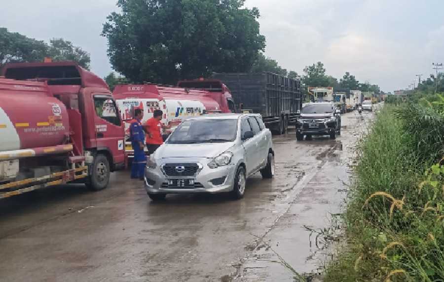 Antrean panjang kendaraan dampak diberlakukannya sistem buka tutup akibat masih banjir yang merendam badan Jalintim Km 83 Desa Kemang Kecamatan Pangkalan Kuras, Pelalawan, Jumat (14/3/2025).