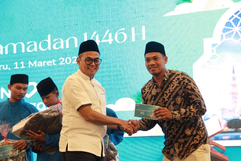 Direktur Human Capital and Compliance BNI Mucharom menyerahkan santunan kepada anak panti saat safari Ramadan di Hotel Pangeran, Selasa (11/3/2025).
