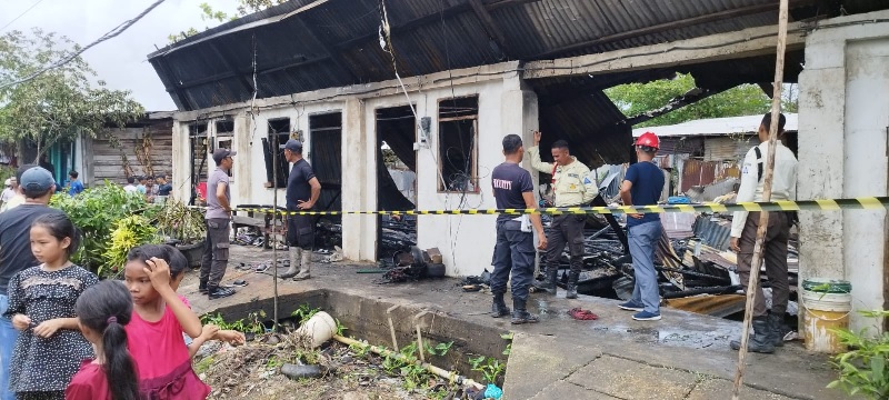 Petugas memasang garis polisi di lokasi kebakaran di Blok H 13 PT RSUP Desa Pulau Burung, Kecamatan Pulau Burung, Indragiri Hilir , Ahad (16/3/2025).