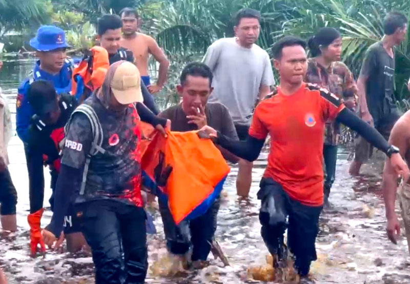 Petugas gabungan dan warga mengevakuasi jenazah balita korban yang tenggelam di kanal PT PKS, Pelalawan, Ahad (16/3/2025).