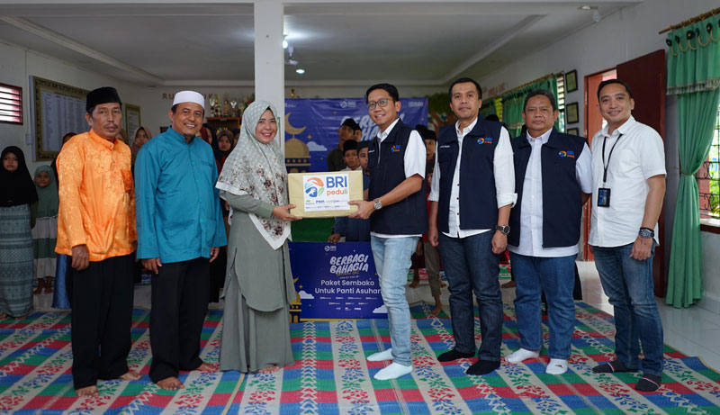 Direktur Digital dan Teknologi Informasi BRI (empat kanan), didampingi RCEO BRI Regional Office Pekanbaru (tiga kanan) dan RCA BRI Pekanbaru (dua kanan) menyerahkan bantuan ke Panti Asuhan.