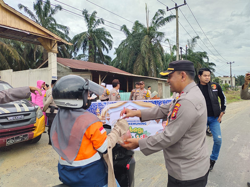 Kapolsek Kemuning Kompol AR Tarigan MH ketika membagikan takjil ke masyarakat di Jalan Lintas Timur, Kemuning, Inhil, Riau, Selasa (18/3/2025).