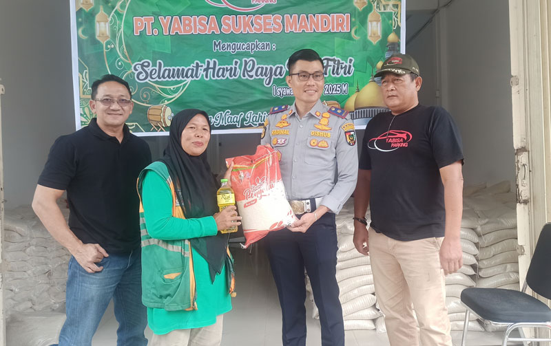 Kepala UPT Perparkiran Dishub Pekanbaru Radinal Munandar (dua kanan) didampingi Kepala Divisi Operasional Teknis PT YSM Ichwan Sunadi (kiri) menyerahkan sembako.