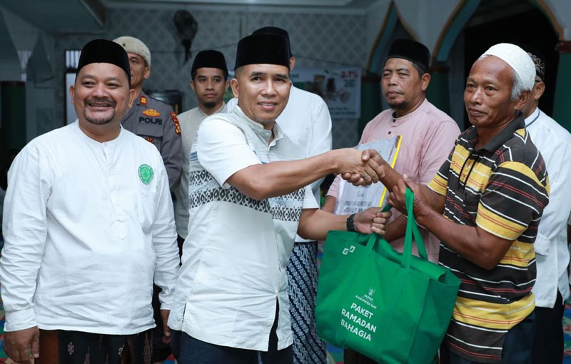 Kadiskominfo Siak Romy Lesmana membagikan paket bantuan kepada yang berhak saat Safari Ramadan di Masjid Al-Barokah, Kampung Rawang Kao, Kecamatan Lubuk Dalam, Selasa (18/3/2025).