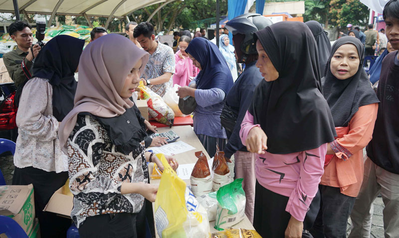 Warga antre berbelanja barang keperluan pokok saat kegiatan Gerakan Pangan Murah di halaman Kantor Bersama Pemerintah Kota Pekanbaru, Jalan Cut Nyak Dien, Pekanbaru.