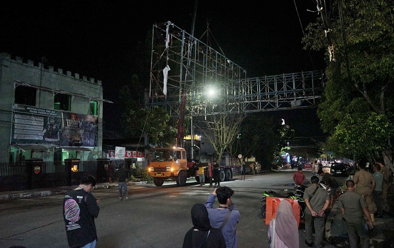 Pekerja melakukan pembongkaran tiang Bando Reklame yang melintang di Jalan Ahmad Yani Pekanbaru, Senin (17/3/2025).