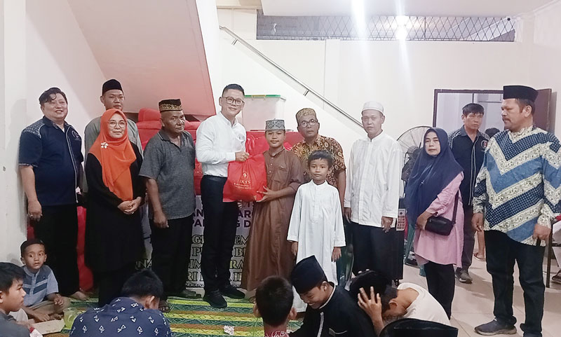Ketua IKTS Pekanbaru Tohan (empat kiri) didampingi Ketua Harian Nata Hedy Nyo (kiri) dan pengurus IKTS lainnya menyerahkan bingkisan Idulfitri kepada anak yatim dan duafa.