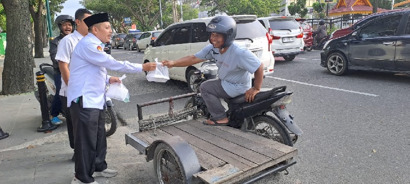 Kepala Kanwil Kemenag Riau, Muliardi sedang membagikan takjil ke warga yang melintas di jalan utama Kota Pekanbaru.