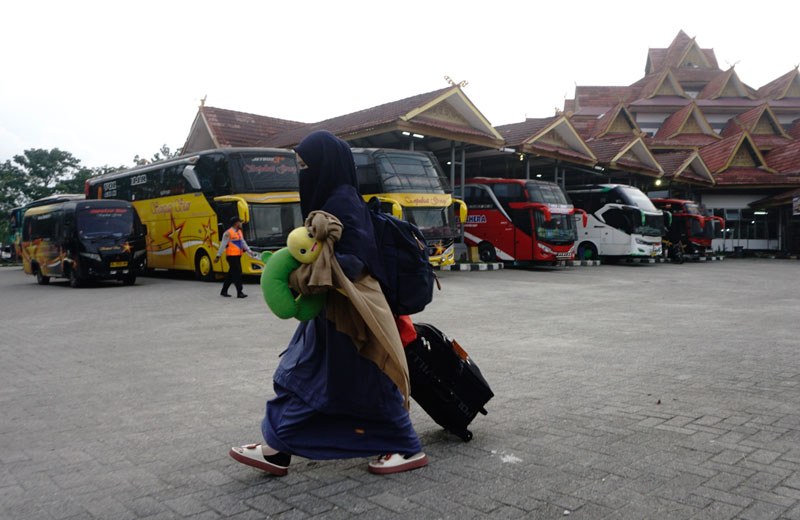 Seorang calon penumpang  menarik koper bawaan saat melintas di Terminal Bandar Raya Payung Sekaki Pekanbaru, Senin (24/3/2025).