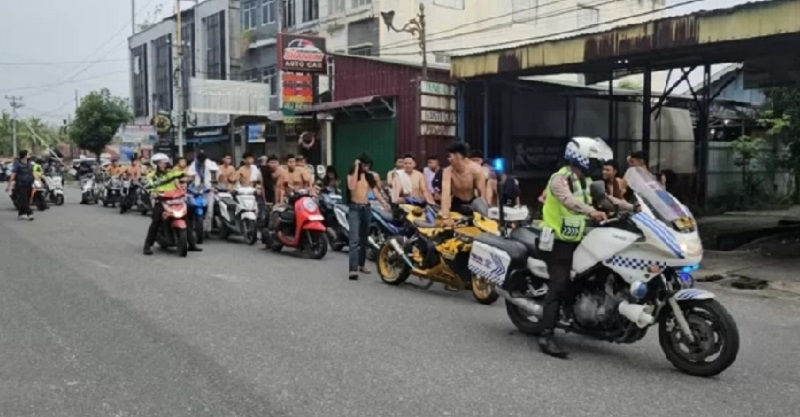 Polisi menggiring dan mengamankan puluhan kendaraan roda dua dalam razia balap liar di Rumbai Pekanbaru, pada Selasa (25/3/2025).