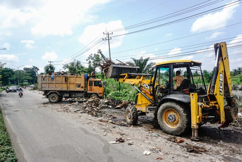 Alat berat mengangkat tumpukan sampah di sepanjang Jalan Soekarno-Hatta, persisnya di depan Pasar Induk Modern Kota Pekanbaru, Selasa (25/3/2025).