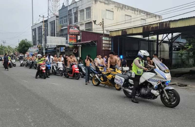 Polisi menggiring dan mengamankan puluhan kendaraan roda dua dalam razia balap liar di Rumbai, Pekanbaru, Selasa (25/3/2025) dini hari.