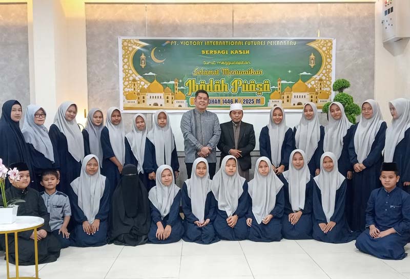 Pimpinan Perusahaan PT Victory International Futures Benni Sutanto (tengah) foto bersama anak yatim dari kedua panti asuhan saat mengadakan buka puasa bersama.