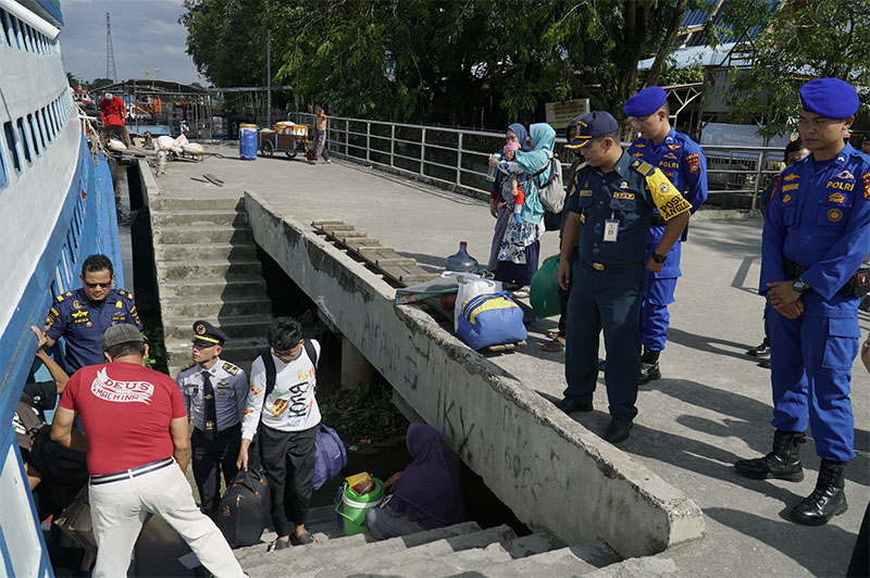 Petugas Pol Airud Polda Riau bersama KSOP Kelas II Pekanbaru berjaga saat penumpang naik ke kapal motor Jelatik II, di Pelabuhan Sungai Duku, Pekanbaru, Kamis (27/3/2025).