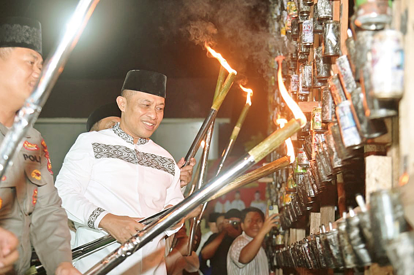 Wabup Bengkalis H Bagus Santoso mema&shy;sang lampu colok pada miniatur masjid di Desa Senggoro, Ke&shy;camatan Bengkalis, Bengkalis, Rabu (26/3/2025) malam.