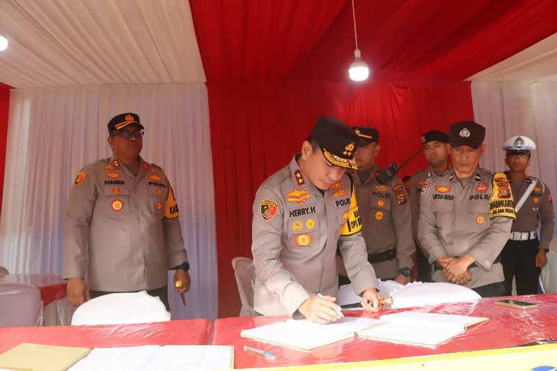 Kapolda Riau Irjen Pol  Herry Heryawan memeriksa buku catatan ketika datang mengunjungi Pos Pengamanan Lebaran di Jalan HR Soebrantas Dumai, , Jumat (28/3/2025).
