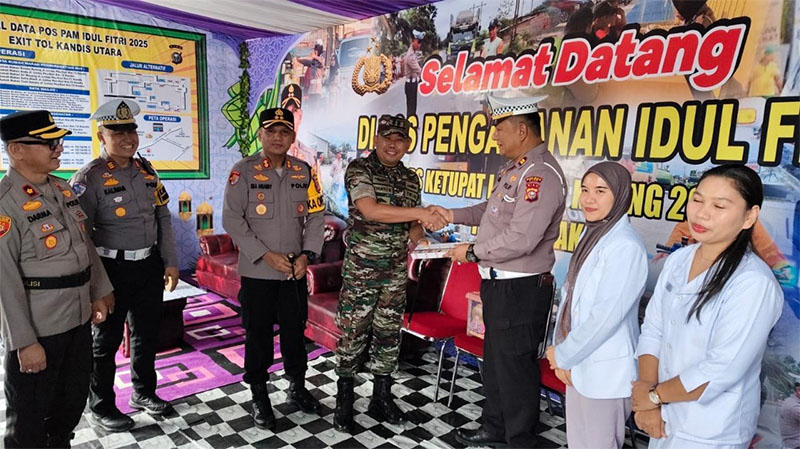 Dandim Siak Letkol Arh Riyanto Budi Nugroho disaksikan Kapolres AKBP Eka Ariandi Putra memberikan bingkisan kepada petugas yang ada di pos pengamanan dan pelayanan Exit Tol Kandis, Jumat (28/3/2025).