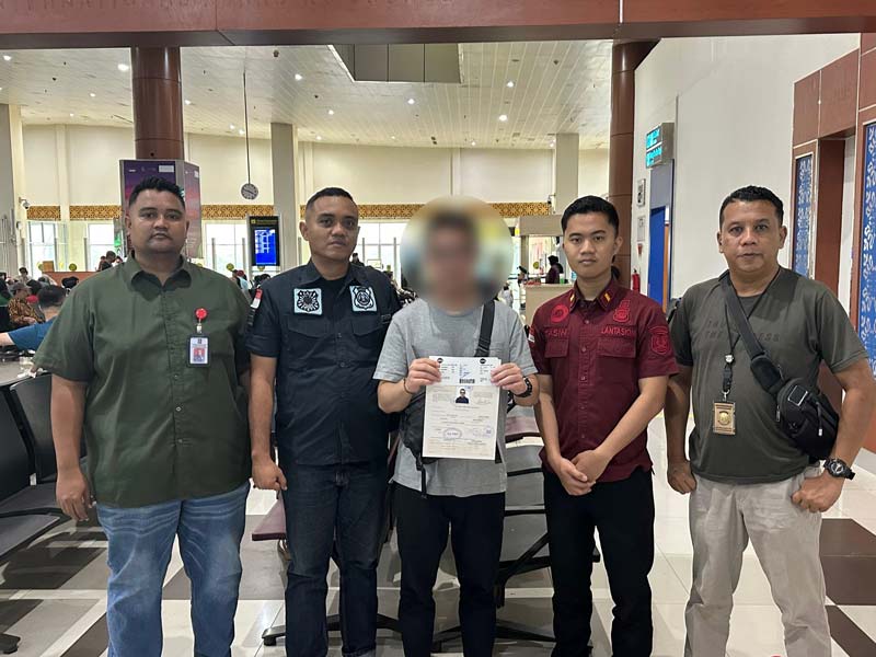 Warga Singapura KK (46)  diapit  petugas Imigrasi Pekanbaru saat proses pendeportasian,  Ahad (30/3/2025).